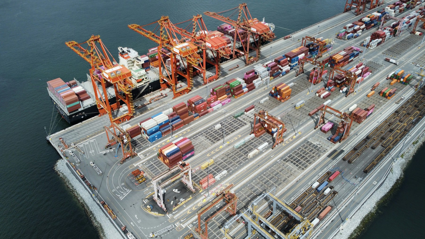 An aerial view of cranes, vessels and connected logistics operations at a port